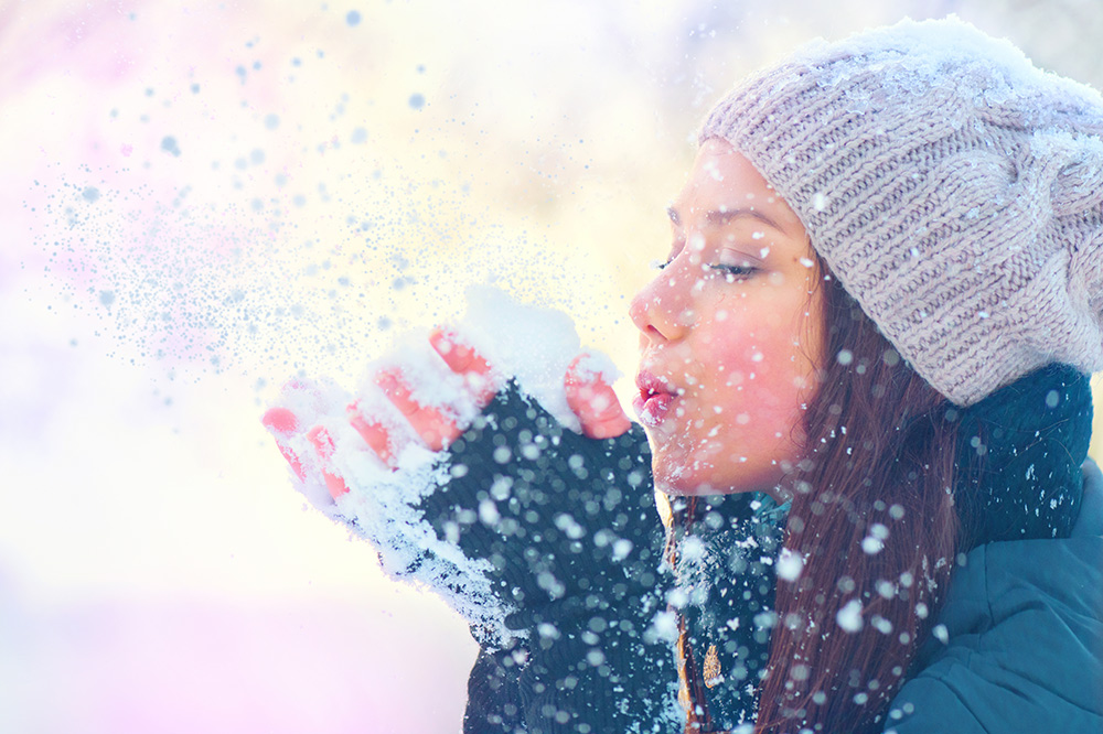 woman wrapped up for winter playing in the snow