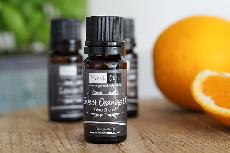 Sweet Orange Essential Oil in bottle with orange